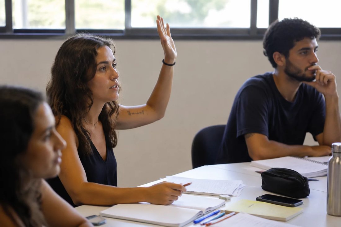 Facilitador em pé apontando para um argumento escrito no quadro durante a sessão